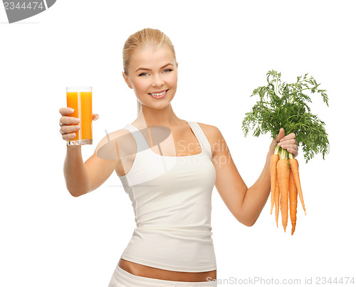 Image of woman holding glass of juice and carrots