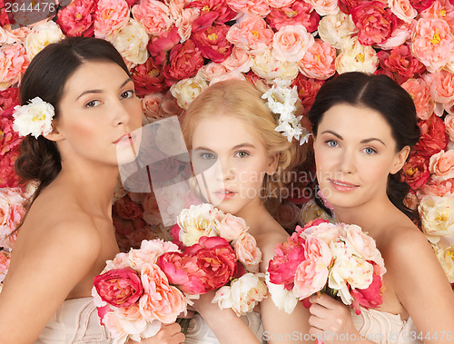 Image of three women with background full of roses