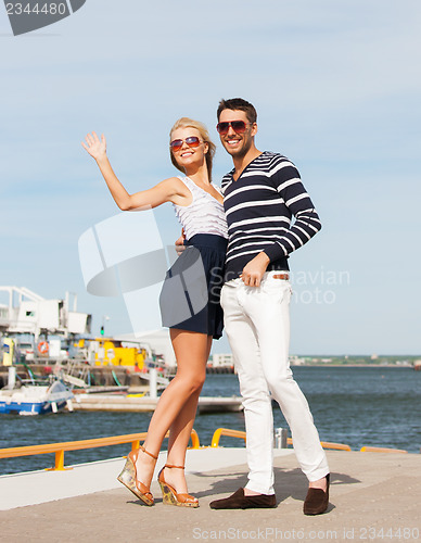 Image of Couple standing and waving in port
