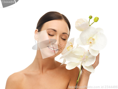 Image of smiling woman with white orchid flower