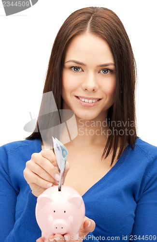 Image of lovely woman with piggy bank and money