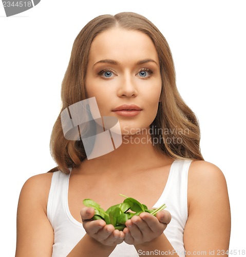 Image of woman with spinach leaves on palms