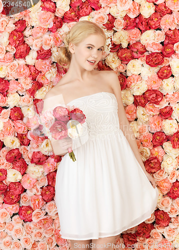 Image of woman with bouquet and background full of roses