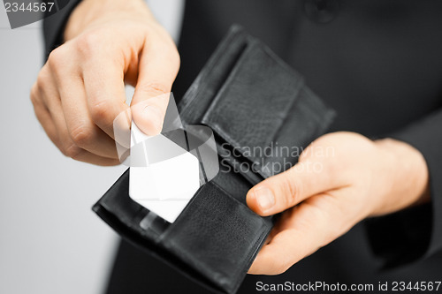 Image of man in suit holding credit card