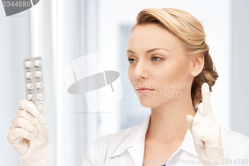 Image of attractive female doctor with pills