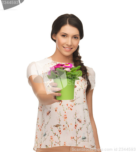 Image of lovely housewife with flower in pot