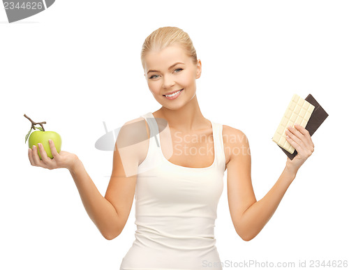 Image of sporty woman with apple and chocolate bars