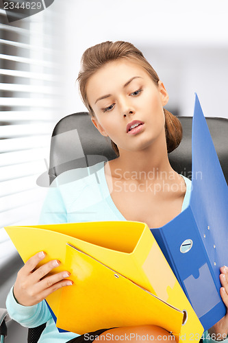 Image of young businesswoman with folders sitting in chair