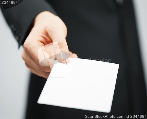 Image of man in suit holding credit card