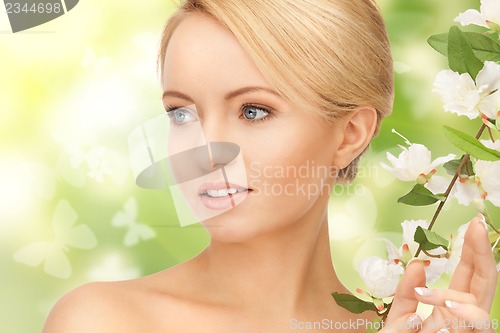 Image of beautiful woman with flowers on twig