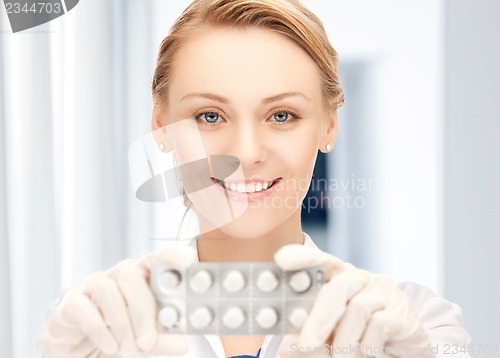 Image of attractive female doctor with pills