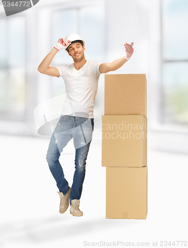 Image of handsome builder with big boxes