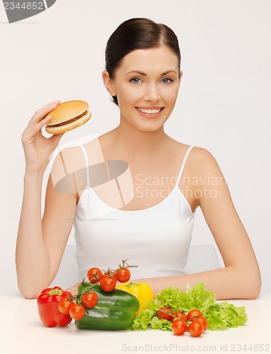 Image of woman with hamburger and vegetables