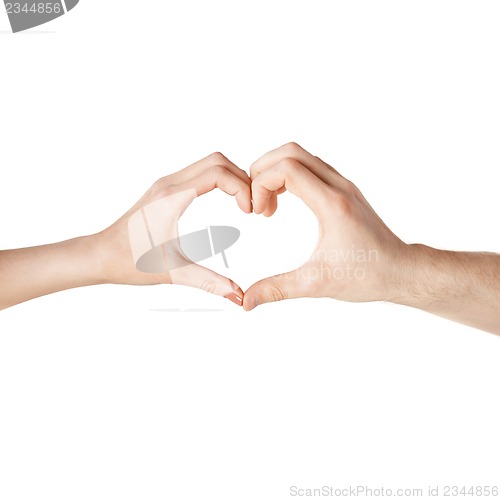 Image of woman and man hands showing heart shape