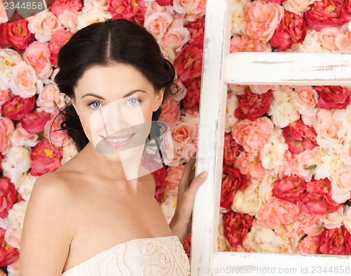 Image of woman with old ladder and background full of roses