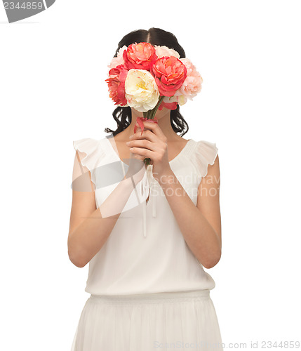 Image of woman holding bouquet of flowers over her face