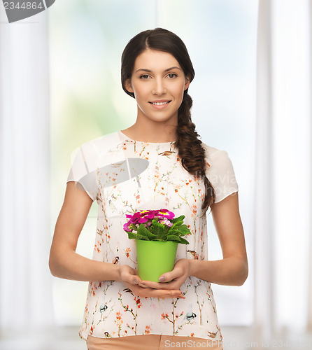 Image of lovely housewife with flower in pot