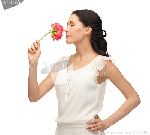 Image of young and beautiful woman smelling flower