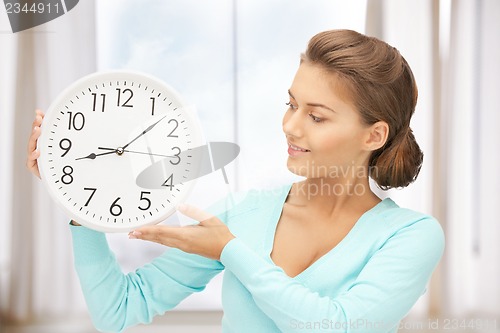 Image of woman holding big clock