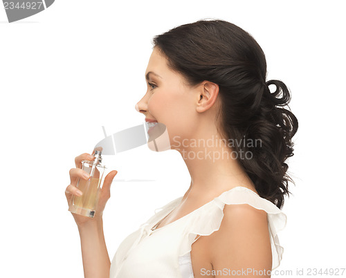 Image of woman spraying perfume on her neck