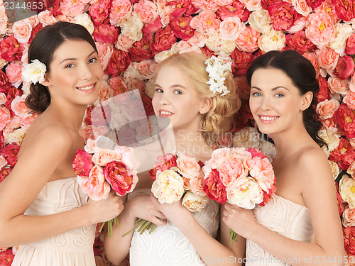 Image of three women with background full of roses
