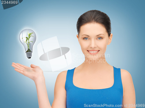 Image of woman showing green light bulb