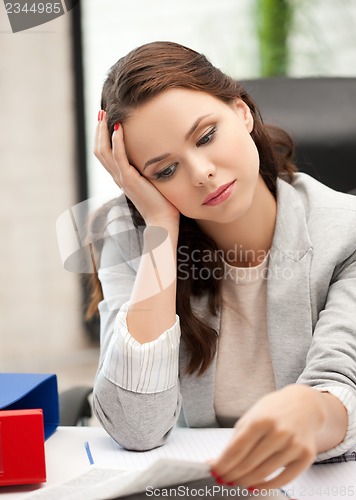 Image of bored and tired woman behid the table