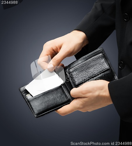 Image of man in suit holding credit card