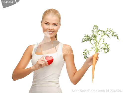 Image of woman holding heart symbol and carrot