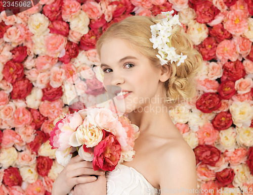 Image of woman with bouquet and background full of roses