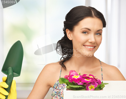 Image of housewife with flower in box and gardening trowel
