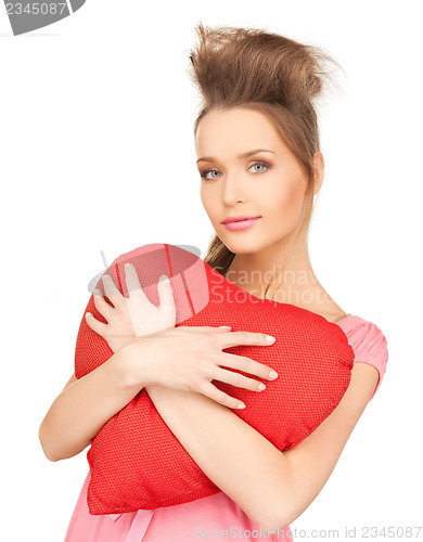 Image of happy and smiling woman with heart-shaped pillow