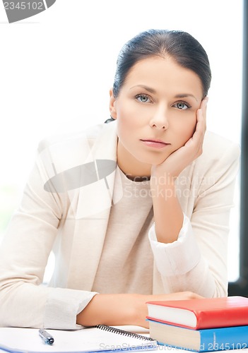 Image of bored and tired woman behid the table