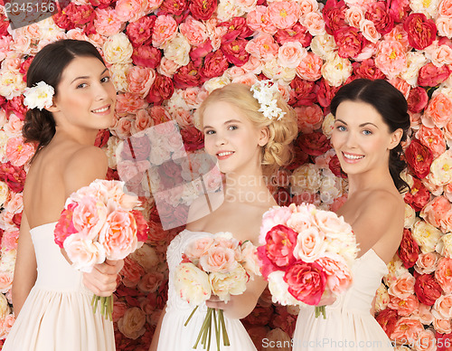 Image of three women with background full of roses