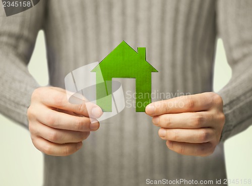 Image of hands holding green house