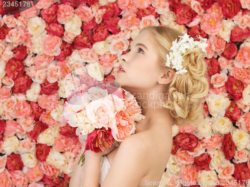 Image of woman with bouquet and background full of roses