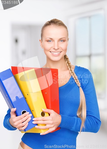 Image of young attractive businesswoman with folders