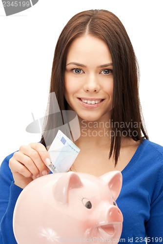 Image of lovely woman with piggy bank and money