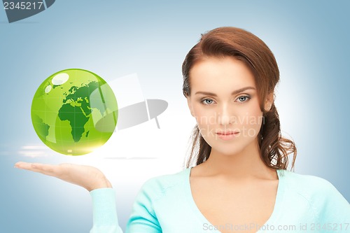 Image of woman holding green globe on her hand