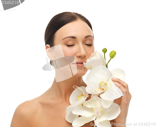 Image of woman smelling white orchid flower