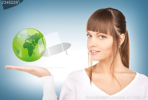 Image of woman holding green globe on her hand