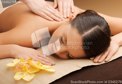 Image of woman in spa salon lying on the massage desk
