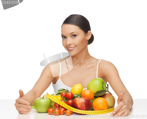 Image of woman with measuring tape and lots of fruits