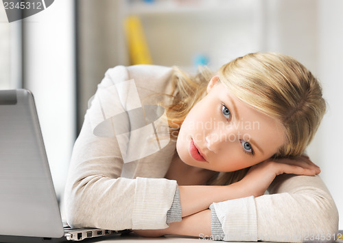 Image of bored and tired woman behind the table