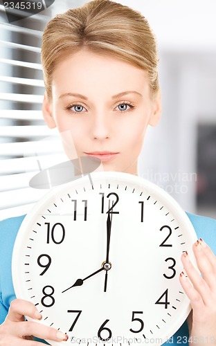 Image of woman holding big clock