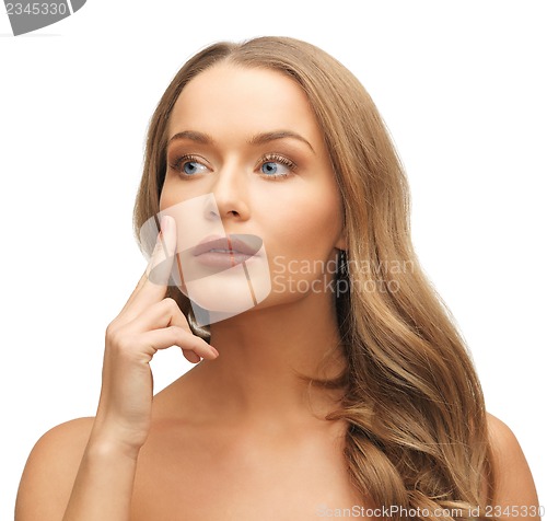 Image of beautiful woman pointing to cheek