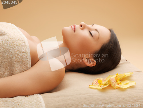 Image of woman in spa salon lying on the massage desk