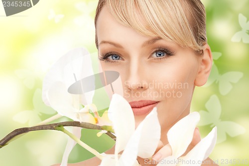 Image of beautiful woman with orchid flower and butterflies