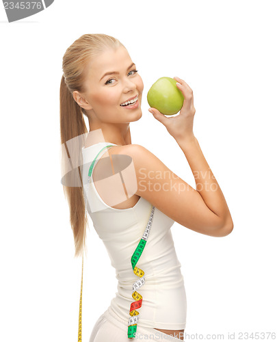 Image of sporty woman with apple and measuring tape
