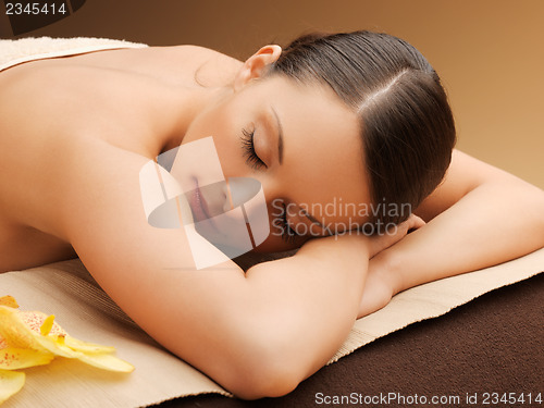 Image of woman in spa salon lying on the massage desk